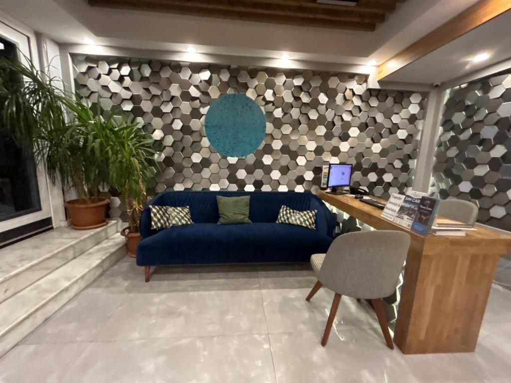 a living room with a blue couch and a desk at Basilis Hotel in Istanbul