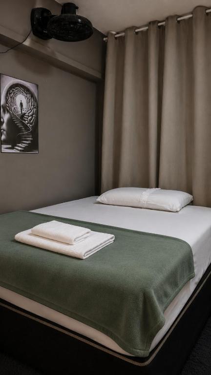 a bedroom with two beds with towels on them at Jams Hostel - Pousada em Catalão in Catalão