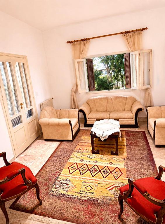 a living room with a couch and a table and chairs at Spacious Mountain House In Sehayleh in Ḩayy ash Shabbūq
