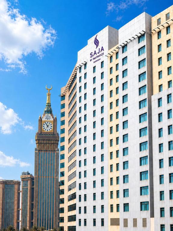 a tall building with a clock tower in front of it at SAJA By Warwick Makkah Hotel in Mecca