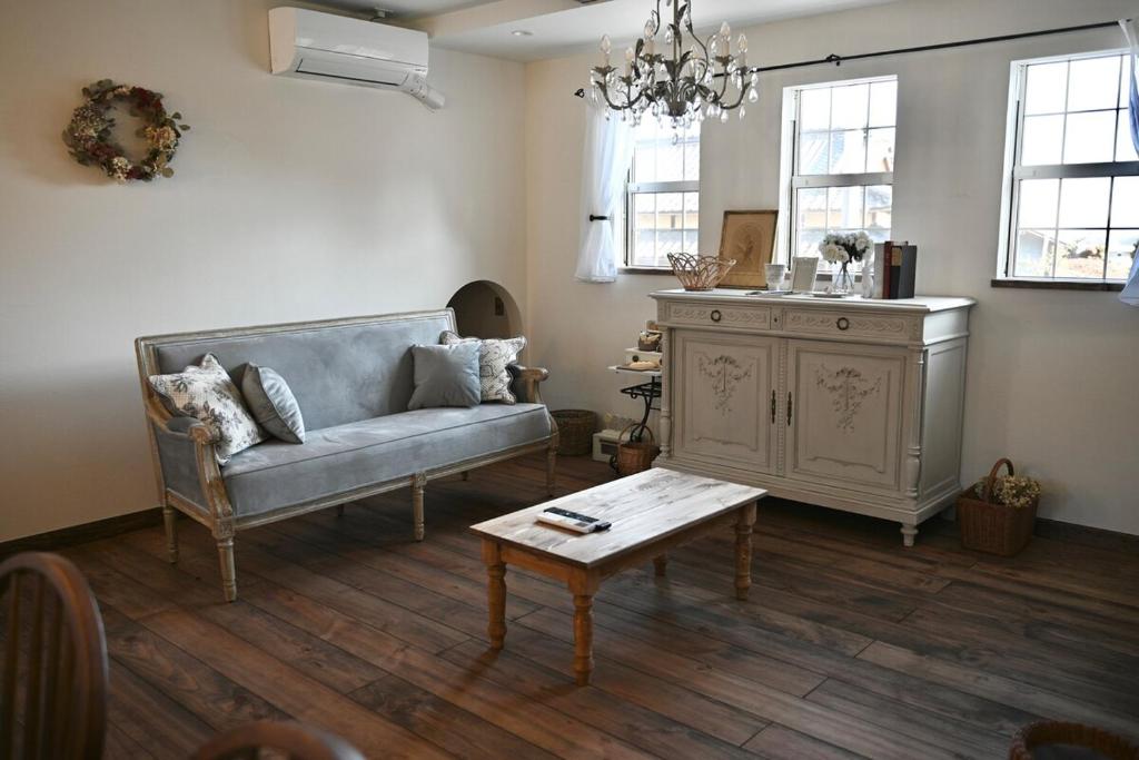 a living room with a couch and a coffee table at Maison de L in Hokuto