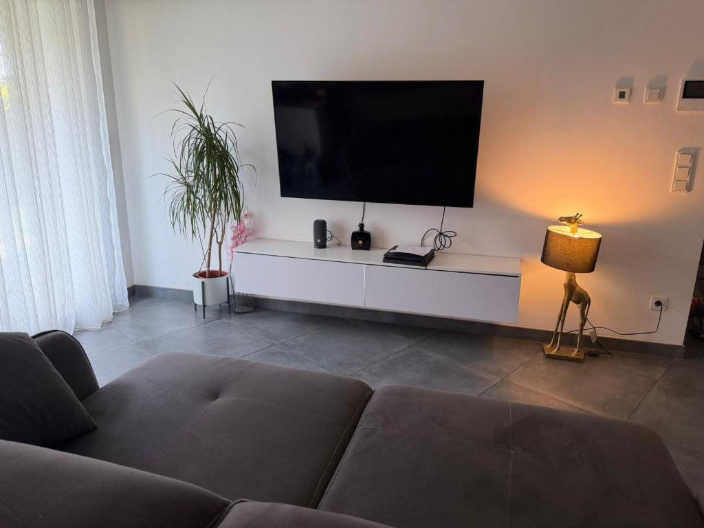 a living room with a couch and a flat screen tv at Terraced apartment in Kayl