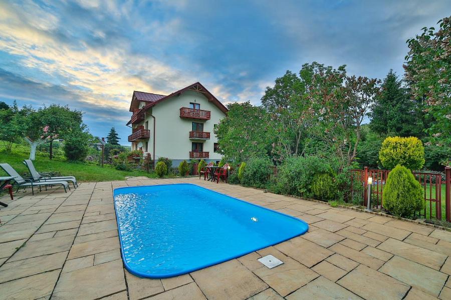 una piscina azul frente a una casa en Ośrodek Wczasowy Sokół en Rabka