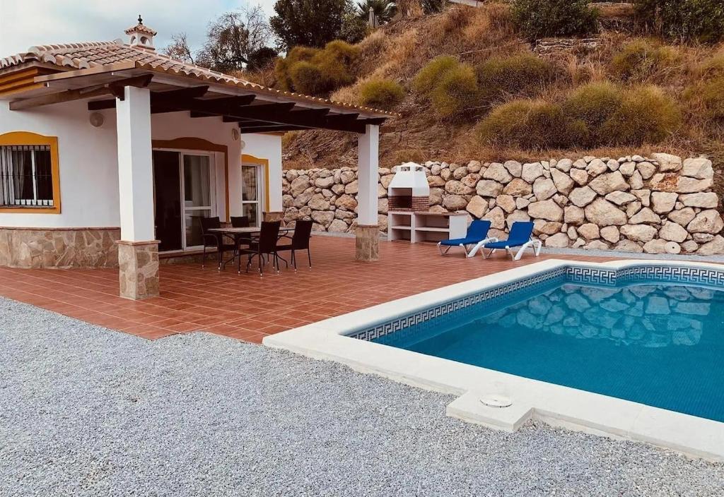 a house with a swimming pool in front of a house at Casa Verdejo in Cómpeta