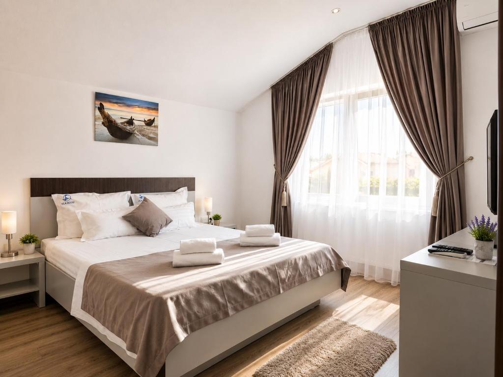 a bedroom with a large bed and a large window at Vila Class in Eforie Nord