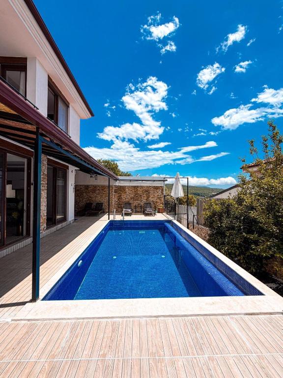 a swimming pool in the backyard of a house at Comfy Villa Ipek with Pool in Kaş