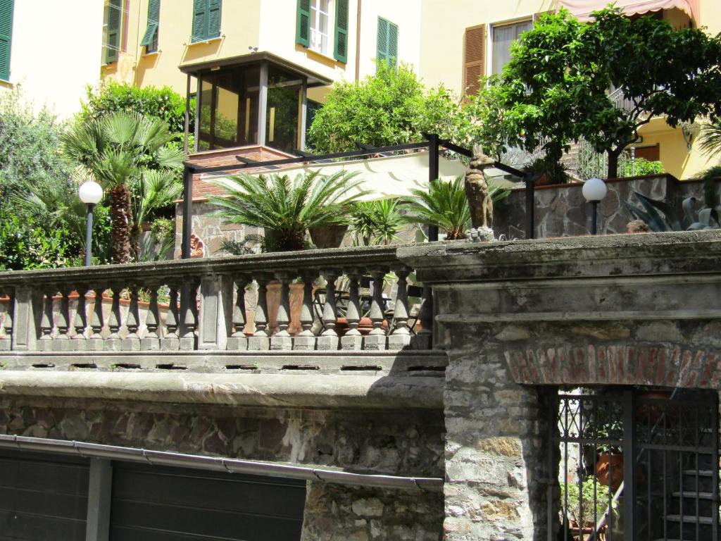 une clôture devant un bâtiment arboré dans l'établissement Glam Resort Villa Maria Luigia, à La Spezia