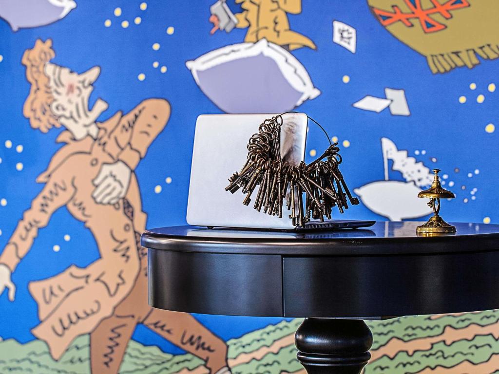 a table with a laptop on it with a wall at ibis Styles Genève Carouge in Geneva