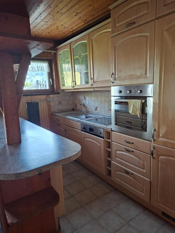 a kitchen with wooden cabinets and a stove top oven at Le Paradis du Chalet Perce-Neige in Châtel-Saint-Denis