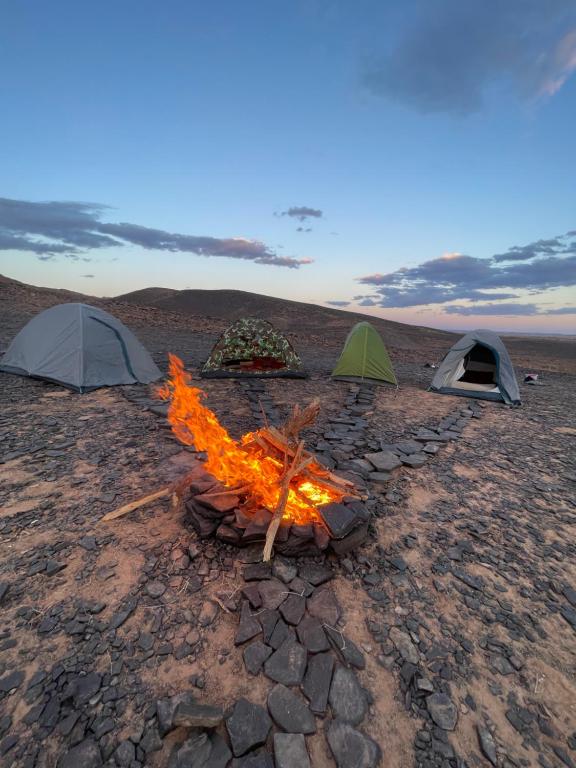 three tents and a camp fire in the desert at Desert mountains camping in Merzouga