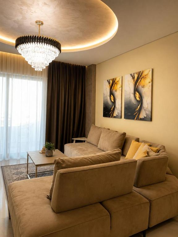 a living room with a couch and a chandelier at Nova Apartaments Qerret ZL in Golem