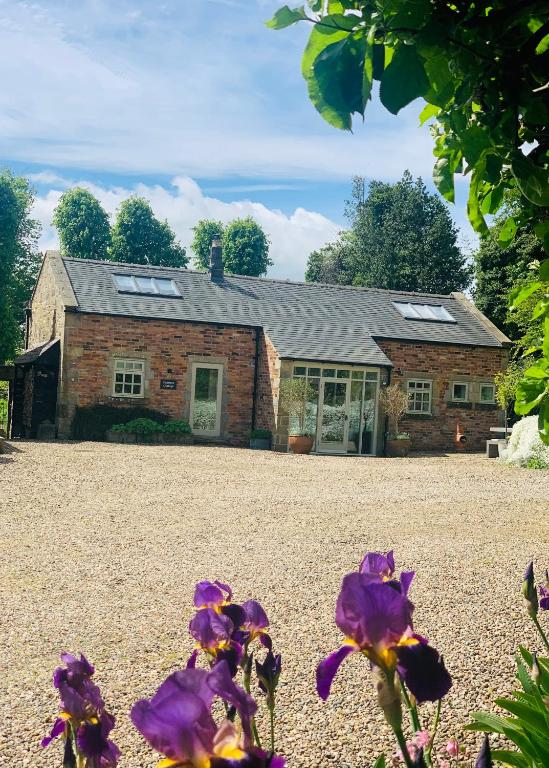 a house with purple flowers in front of it at Peartree Cottage in Sandhoe