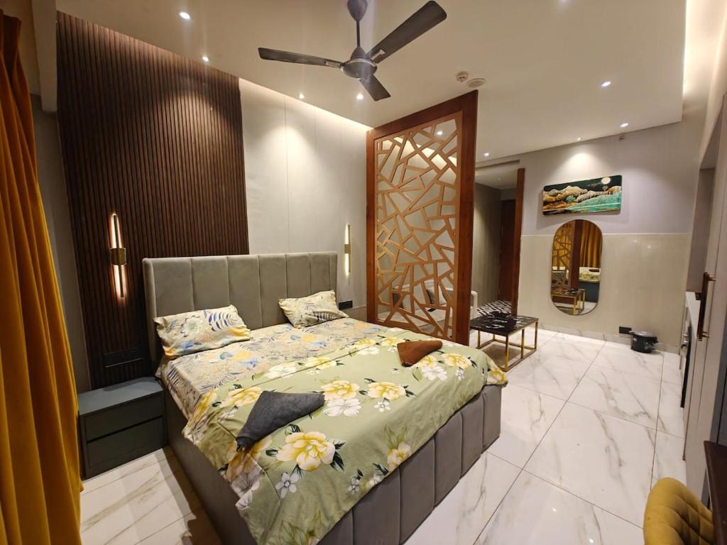 a bedroom with a bed and a ceiling fan at Darshana Studios#Galaxyblue sapphire#Stylish in Ghaziabad