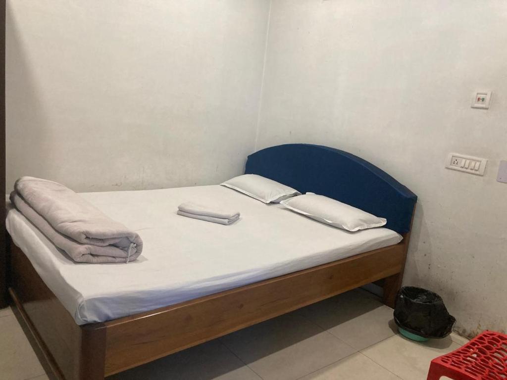 a small bed with a blue headboard in a room at Blue Horizon hotel & restaurent in Nalbāri