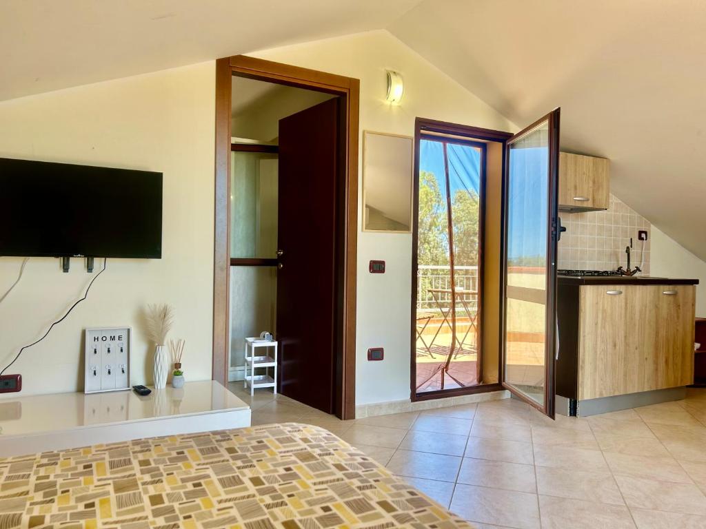 a bedroom with a bed and a sliding glass door at AgroVerde Apartment a 10 minuti da Alghero in Tottubella
