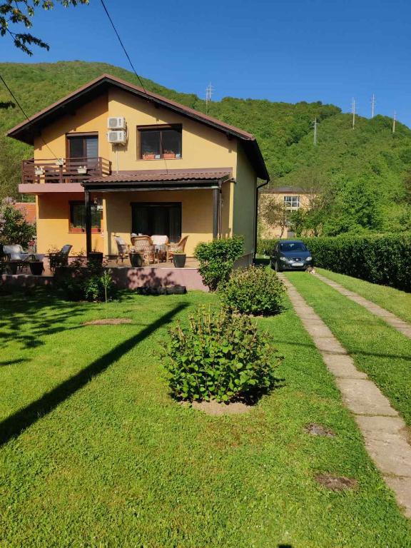 a house with a car parked in front of it at Vrelo Bosne 10 in Vrelo Bosne