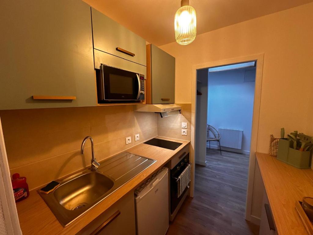 a kitchen with a sink and a microwave at Palma Verde - centre ville - wifi in Niort
