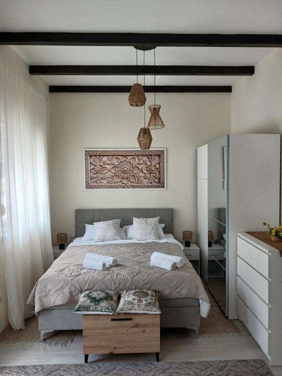 a bedroom with a large bed and a table at Studio D lux Vida in Apatin