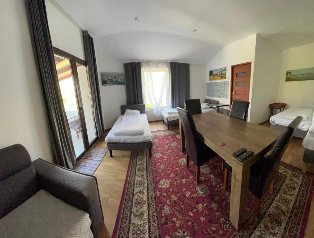 a living room with a dining table and a couch at Pokoje Gościnne Pocztacaffe in Gdynia