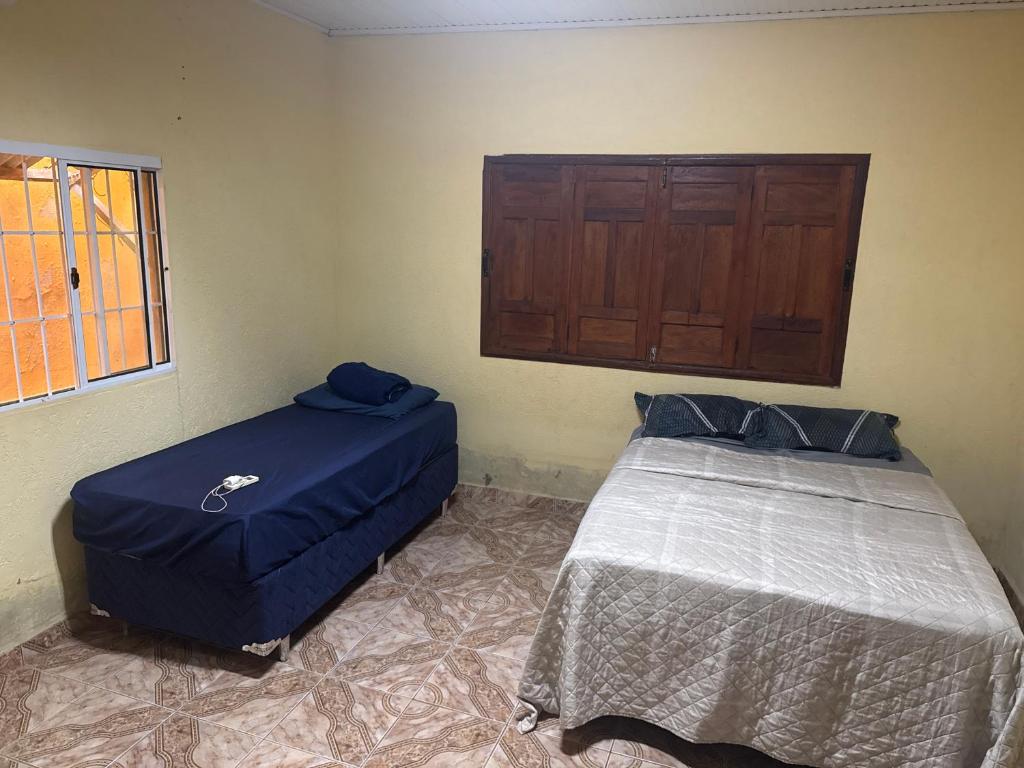 a bedroom with two beds and a window at Casa com Quartos compartilhados in Rio Branco
