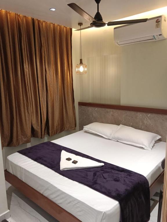 a bedroom with a bed with a towel on it at Shri Guru Prasad in Belgaum