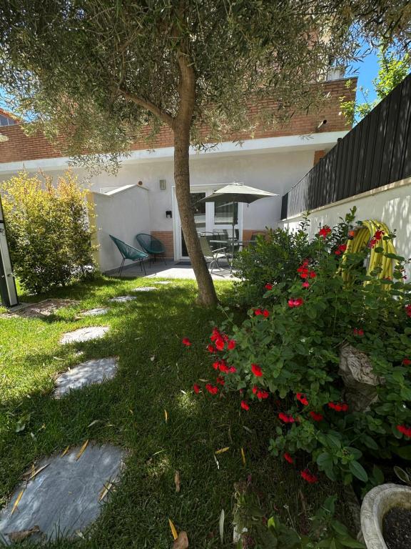 a house with red flowers in the yard at ComfortHouse AlbatrosMare in Ladispoli
