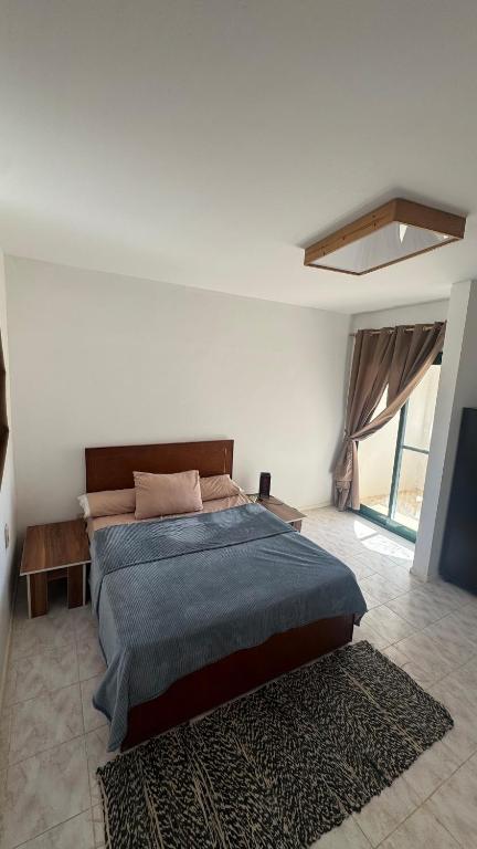 a bedroom with a large bed and a large window at Authentic Cozy Chalet Near the Beach in Ras Sedr