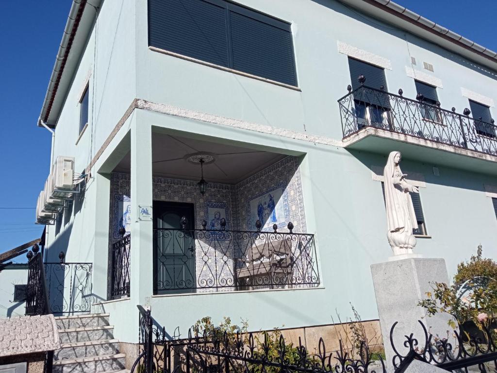 a white building with a statue on a balcony at Meda`s House in Meda