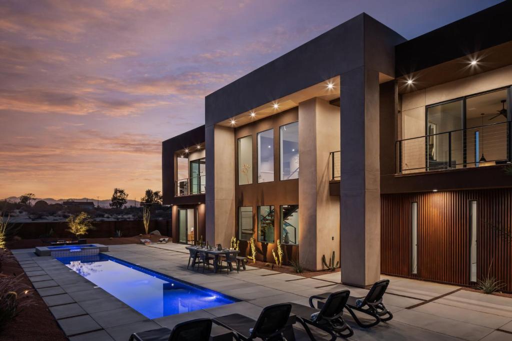 a large house with a swimming pool in front of it at Suncrest by Fieldtrip - JT Modern w Pool and Views in Joshua Tree