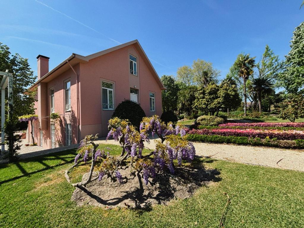 a house with purple flowers in the yard at Casal do Arcebispado in Felgueiras