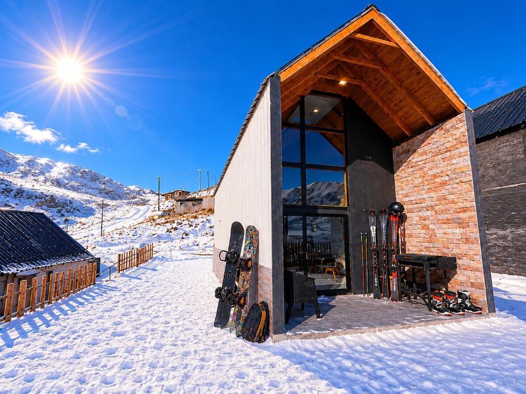 a building with skis parked outside of it in the snow at Casa Malbec en Los Molles in Las Lenas