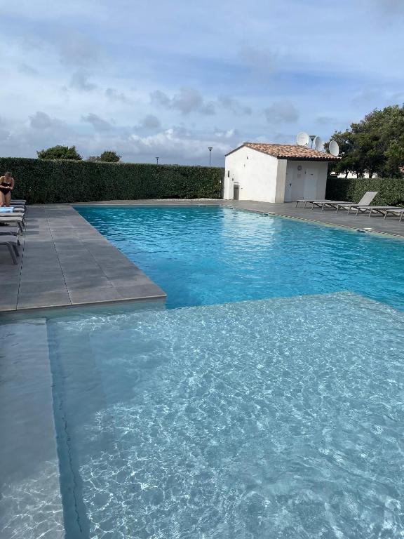 a swimming pool with blue water in front of a building at Villa Léonie in Bonifacio
