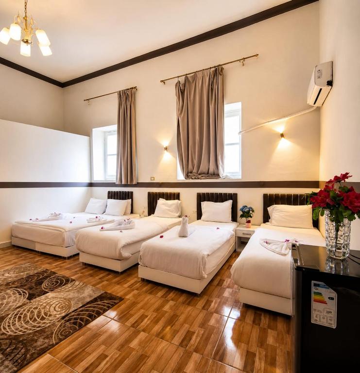 three beds in a room with wood floors at Dawn tawn velavet in Cairo