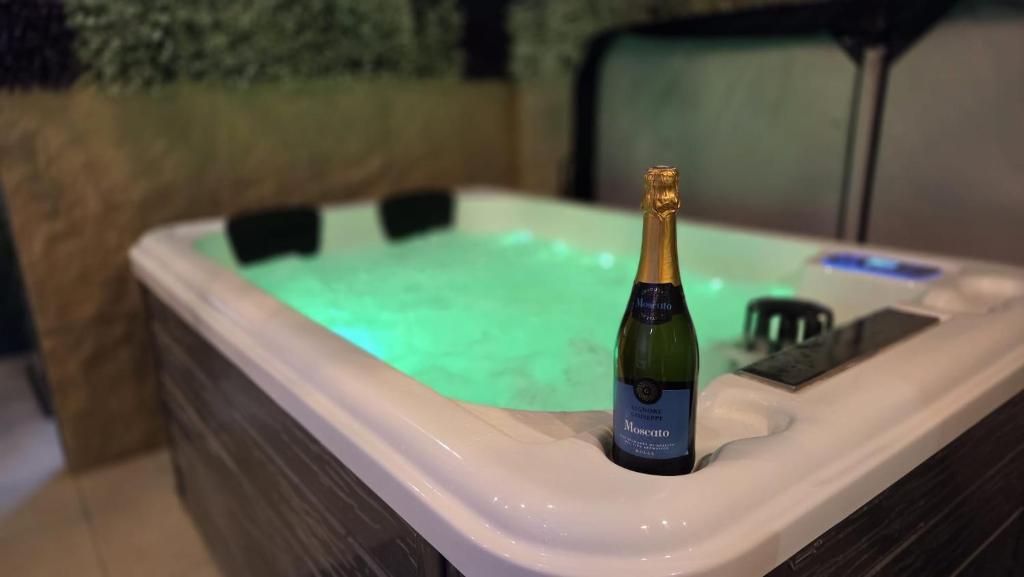 a bottle of champagne in a bath tub at Botanica - Private Spa in Saint-Quentin