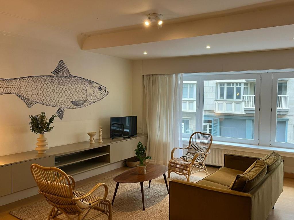 a living room with a fish mural on the wall at Residentie Sweetnest met hotelservice à la carte - 3 dubbel kamers in Knokke-Heist