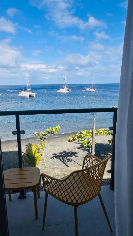 a balcony with a view of the ocean and boats at Hotel Ti' Pelican in Saint-Pierre