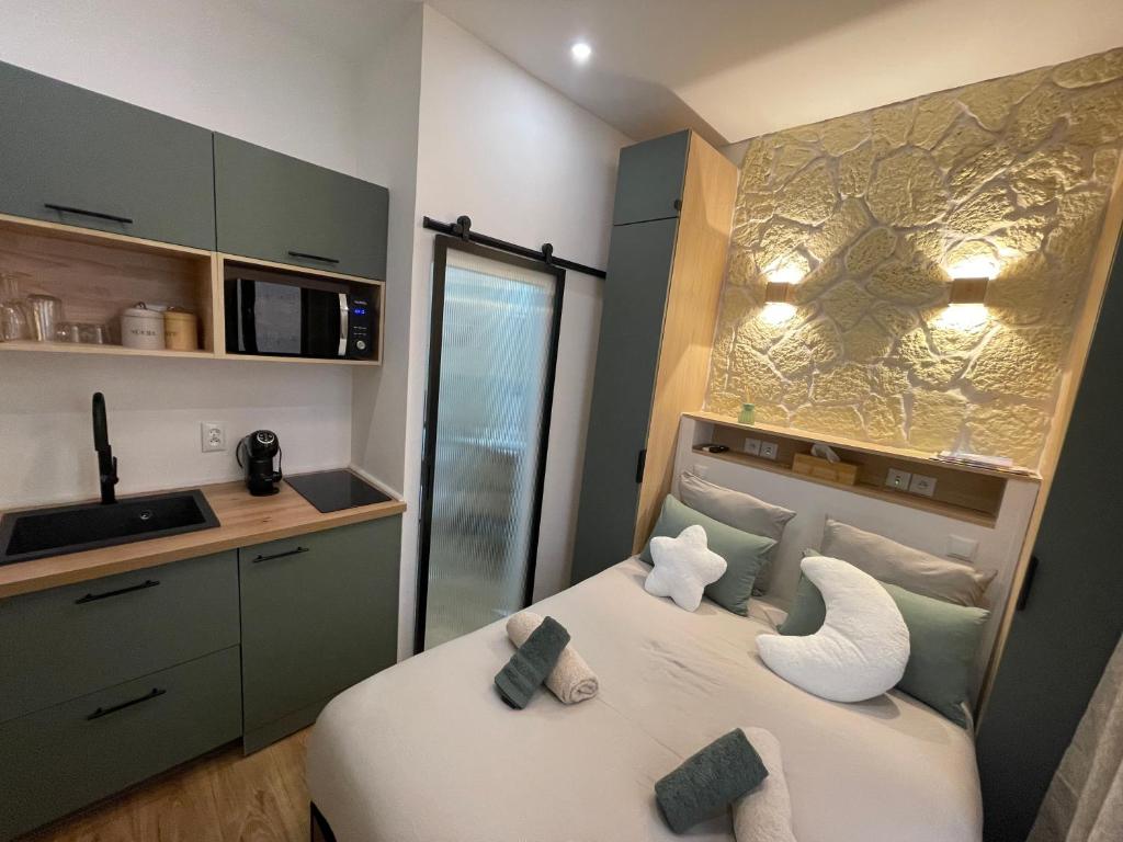 a bedroom with a bed and a kitchen with a sink at Charming cozy nest - old town in Annecy