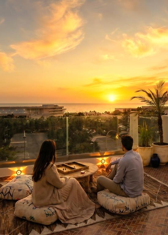 a couple sitting on bean bags watching the sunset at White Majorelle Azul in Tamraght Ouzdar