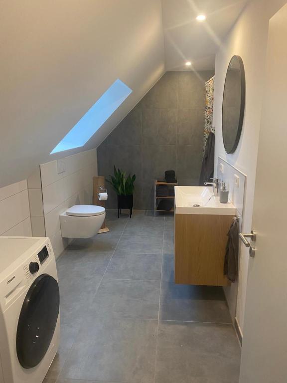 ein Badezimmer mit Toilette, Waschbecken und Fenster in der Unterkunft Hof Husmann in Extertal