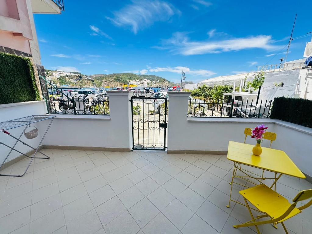 ein Balkon mit einem gelben Tisch und Stühlen in der Unterkunft Marea - Immobilevante in Ponza