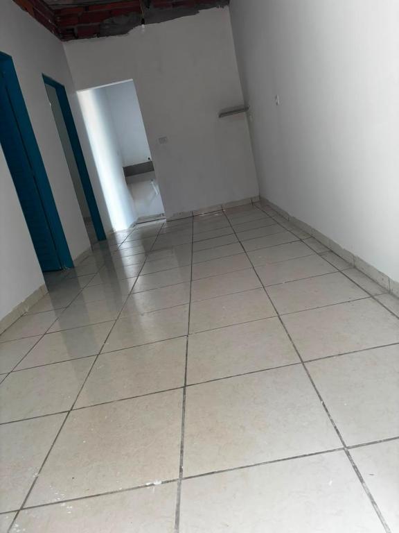 an empty room with a tiled floor and a door at Maria imóveis in Trindade