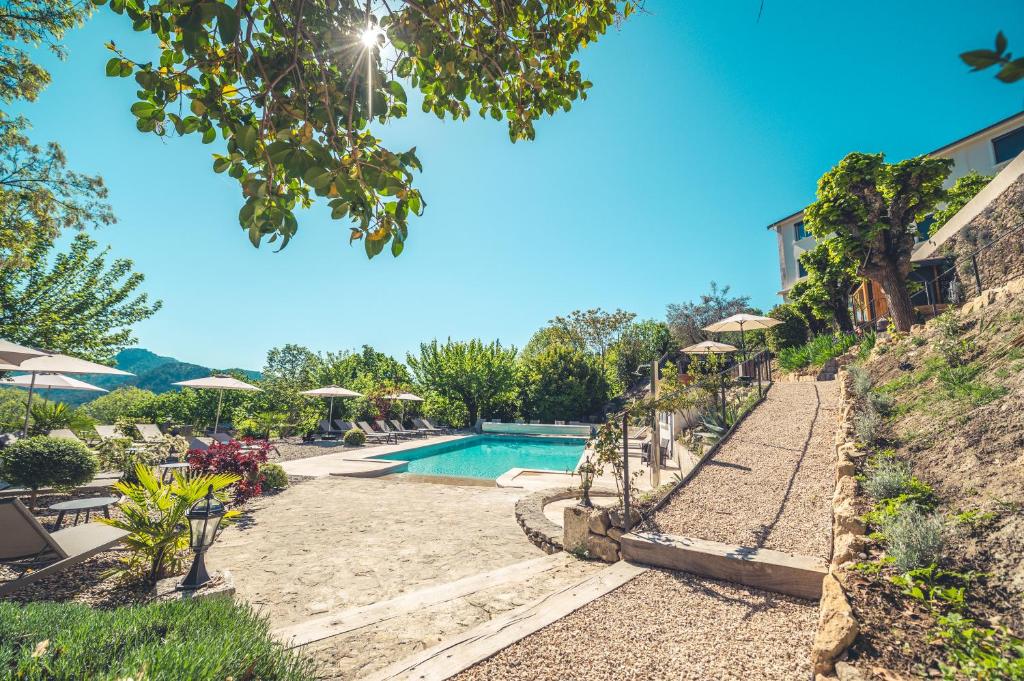 a swimming pool at a villa with a resort at Logis Hôtel Restaurant Le Plantevin in Propiac