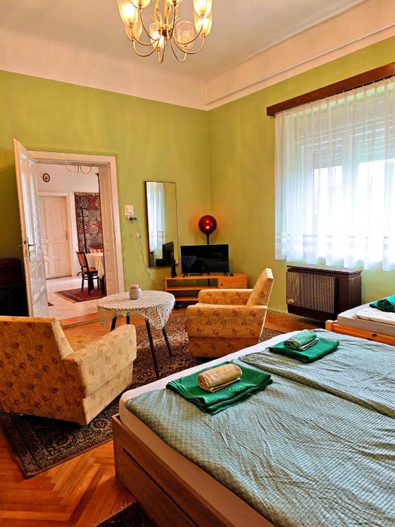 a bedroom with a bed and a living room at Retró Kúria in Fonyód