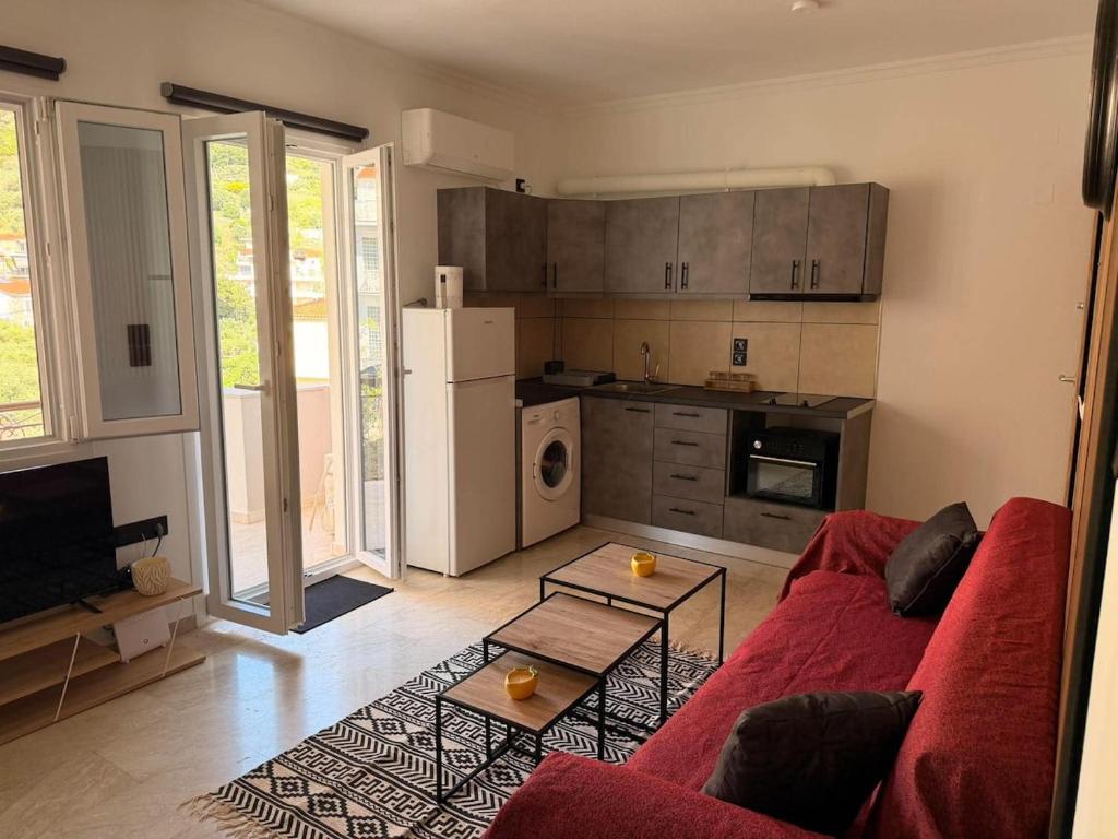 a living room with a red couch and a kitchen at Nature Nest in Samos