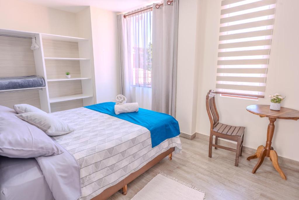 a bedroom with a bed and a table and a chair at Me Gusta Sucre Inn in Sucre