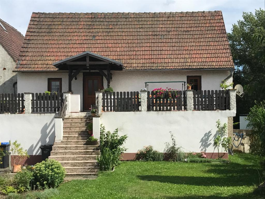 a white house with a fence and a yard at Ferienhaus Sonnenterrasse mit Grill und Garten in Gerstenberg