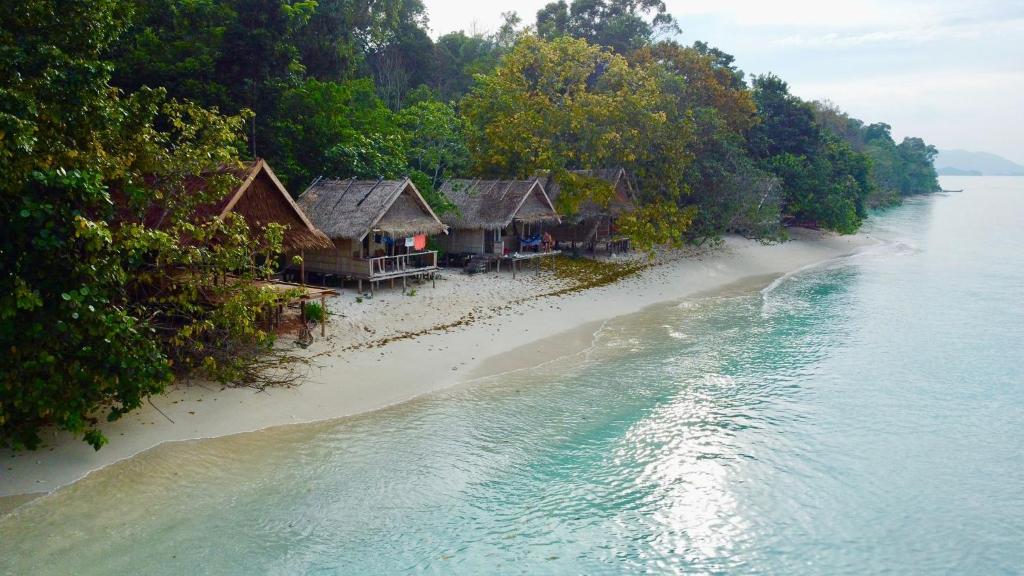 an island with houses on the shore of the water at Batanta Panorama Homestay in Dayang