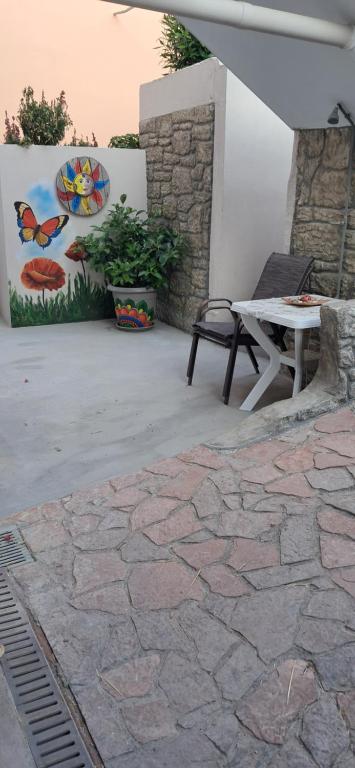 a patio with a bench and a table and a painting at Simos in Vrontádos