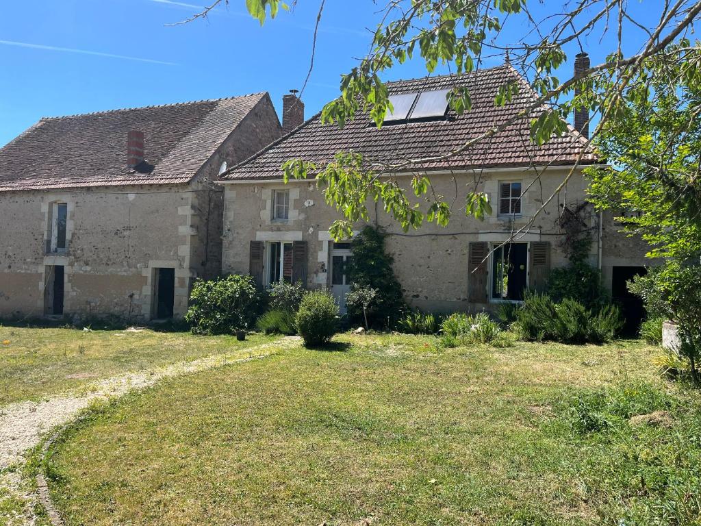 an old stone house with a yard at Le Domaine in Lignac