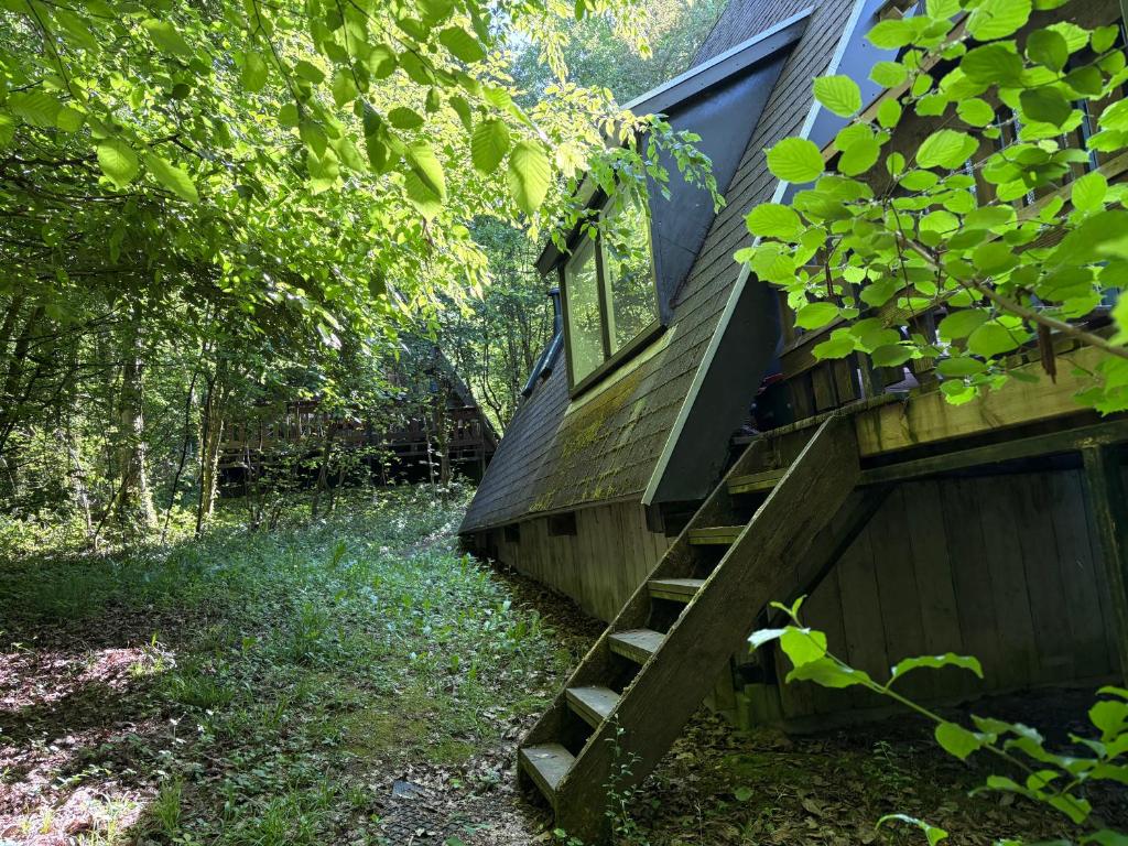 a house with a wooden staircase leading up to it at Sequoia Duo 2 chalets voisins, familles,amis,détente in Durbuy
